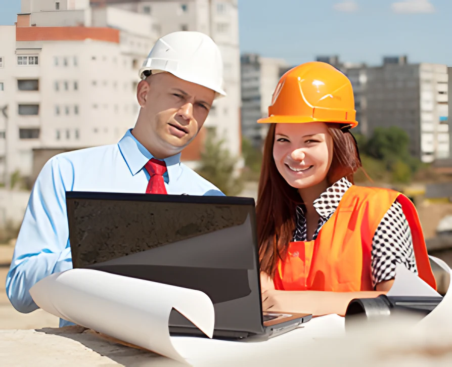 MZ Works site manager and engineer reviewing plans on a laptop on site